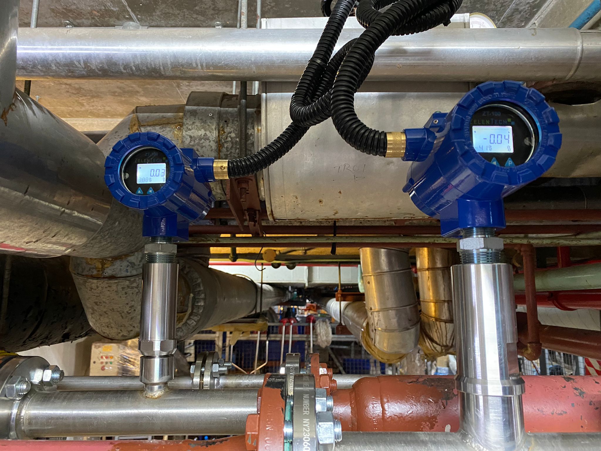 Inline water content monitors installed in a processing facility